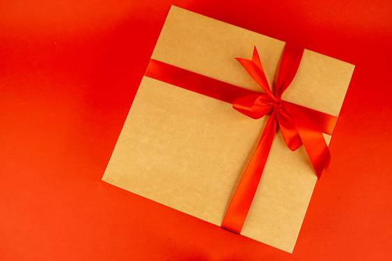 Kotak hadiah dengan pita merah melambangkan bonus member baru